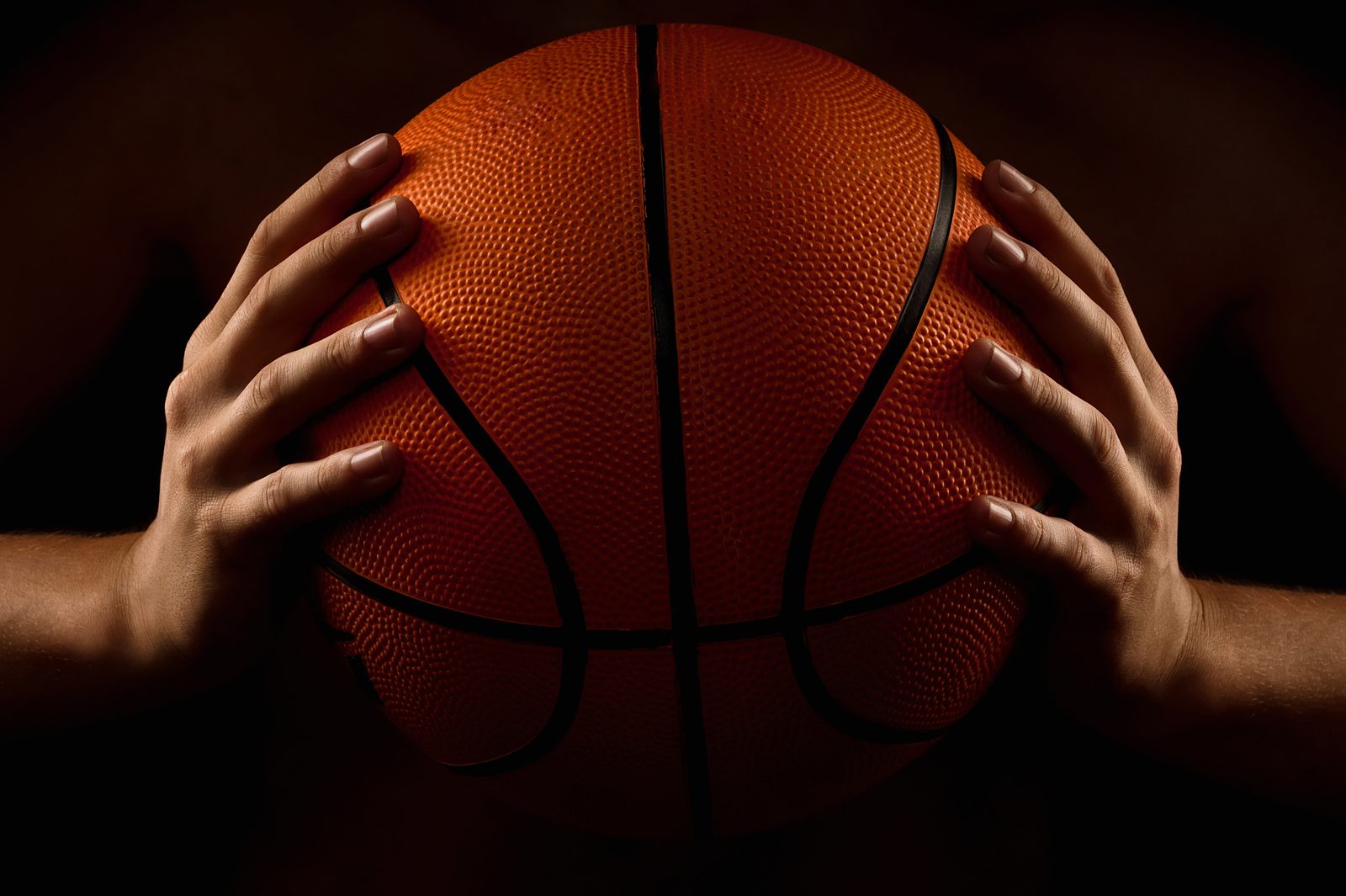 Hands holding a basketball